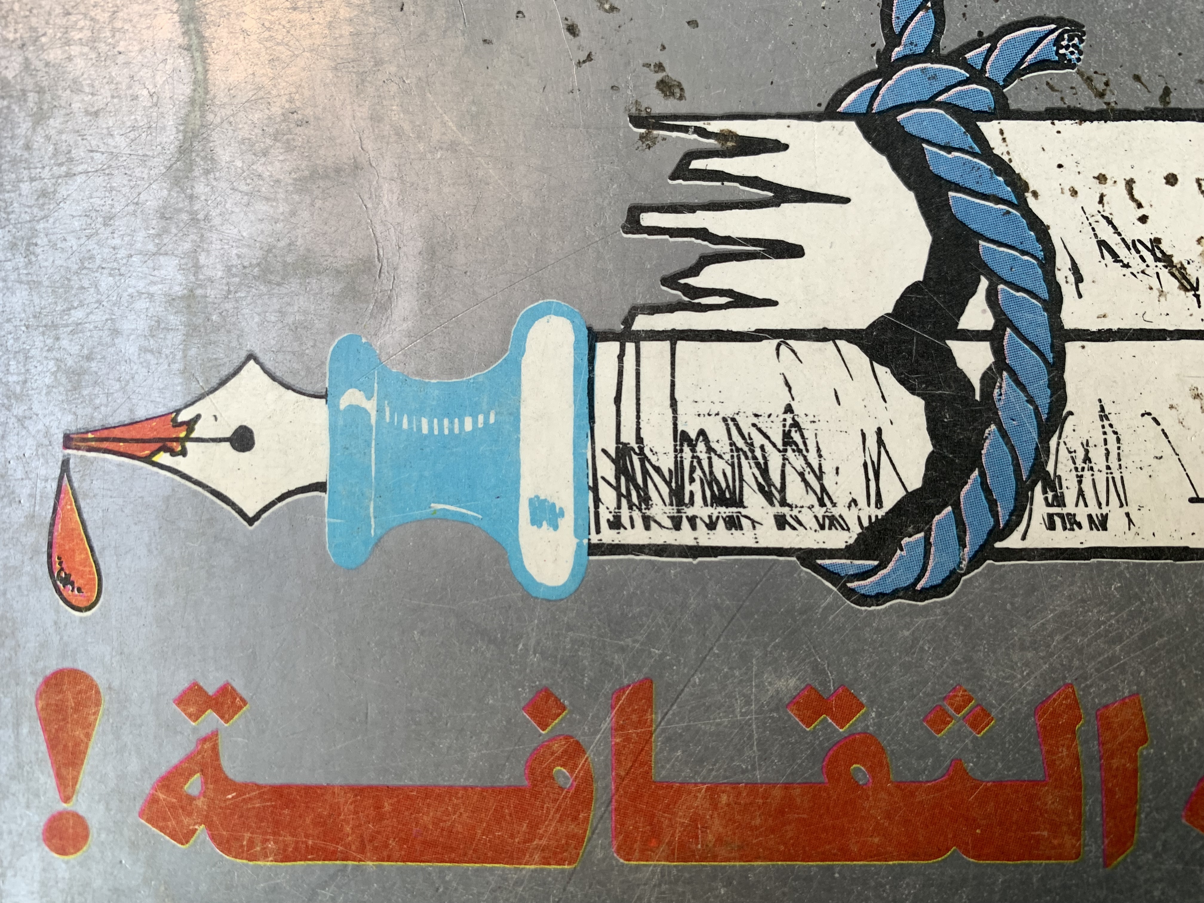 A drawing of a fountain pen lying sideways, with one drop of red ink dripping from the pen's nib. Tied together on top is a pen that is broken in half.